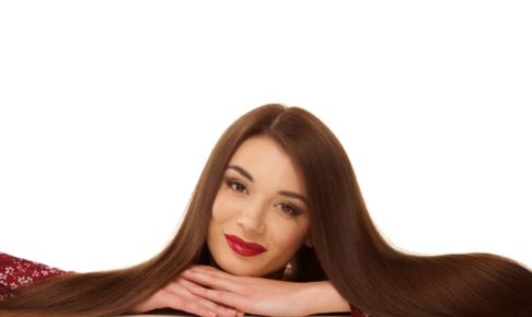 前にアゴを乗せ笑みを浮かべているロングヘアの美女