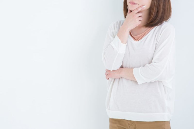 白い服　考えている女性の画像