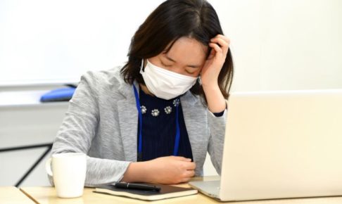 デスク作業中に頭を抱える女性