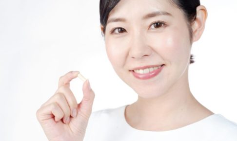 澄んだお顔でサプリメントを示している女性