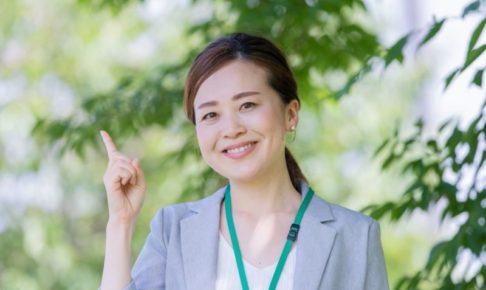 木陰に人差し指を指し示す女性会社員