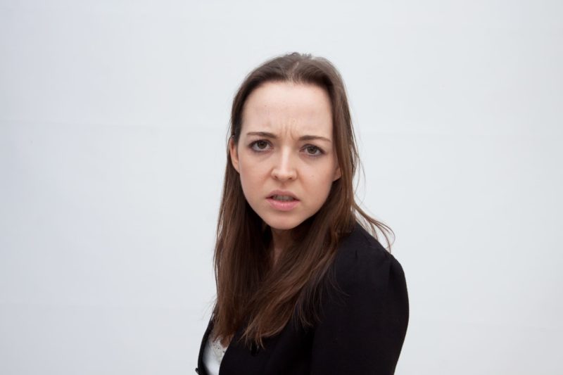 眉間にシワ寄せてしかめっ面をしている女性