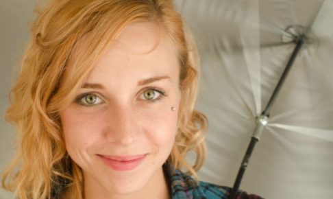 白い傘を持ち少し微笑の表情の金髪外国人