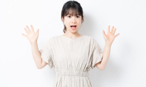 両手を上げて驚いているグレージュワンピの女の子