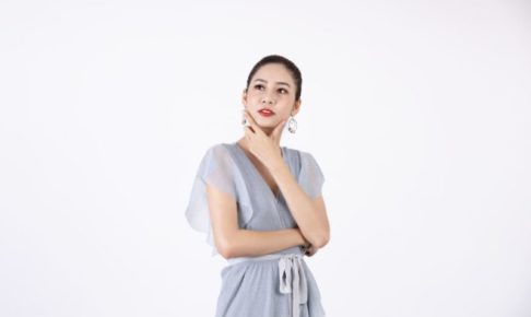 アゴに手を当てて考えている青ワンピの美女