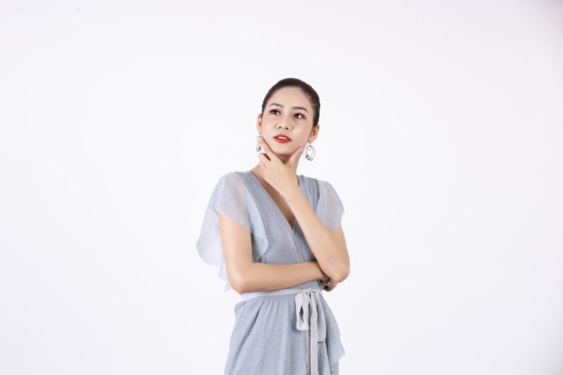 アゴに手を当てて考えている青ワンピの美女