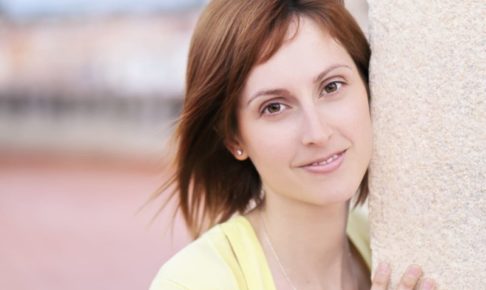 コンクリート柱から顔を出している外国人美女