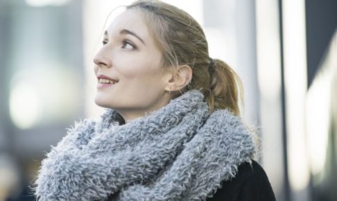 冬の街をスヌードをつけて過ごしている外国人女性