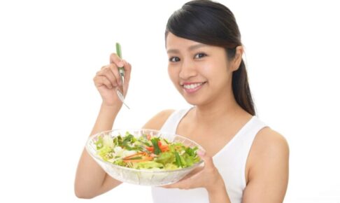 サラダを抱える笑顔の女性