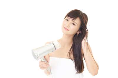 ちゃんとドライヤーから放して髪を乾かしている女性