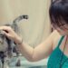 猫を触っている緑色のワンピースの女性