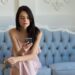ソファーに座ってスマートフォンを操作している外国人女性