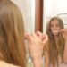 鏡に向かって歯磨きをする外国人女性