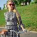 自転車を支えているサングラスをしたノースリーブのワンピースを着用した外国人女性