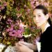ピンクの花を手入れしている花屋の三つ編みした女性