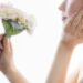 花をもって頬に手を当てる女性