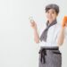 ニンジンとピーラーを持ってるカフェ勤務風の女性