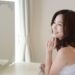 鏡をみてにっこり微笑む女性