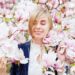 淡い木蓮の花に囲まれてうっとりしている外国人女性