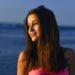 夏の夕暮れの海で陽を浴びている外国人女性のアップ