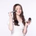 ベージュのチークを塗っているロングヘアの美女