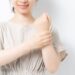 左手首を握っているワンピース姿の女性の上半身