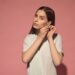 ピンク背景に左耳に大きなピアスをした女の人