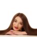 前にアゴを乗せ笑みを浮かべているロングヘアの美女
