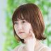 自分の左ほおの様子を確かめているボブ髪の女性