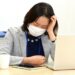 デスク作業中に頭を抱える女性