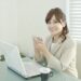 オフィスワークの合間にスマホをいじる女性会社員