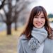 冬の日にグレーのコーデで微笑むロングヘアの女性