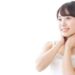 自分の首に触れているキャミソール姿の女性